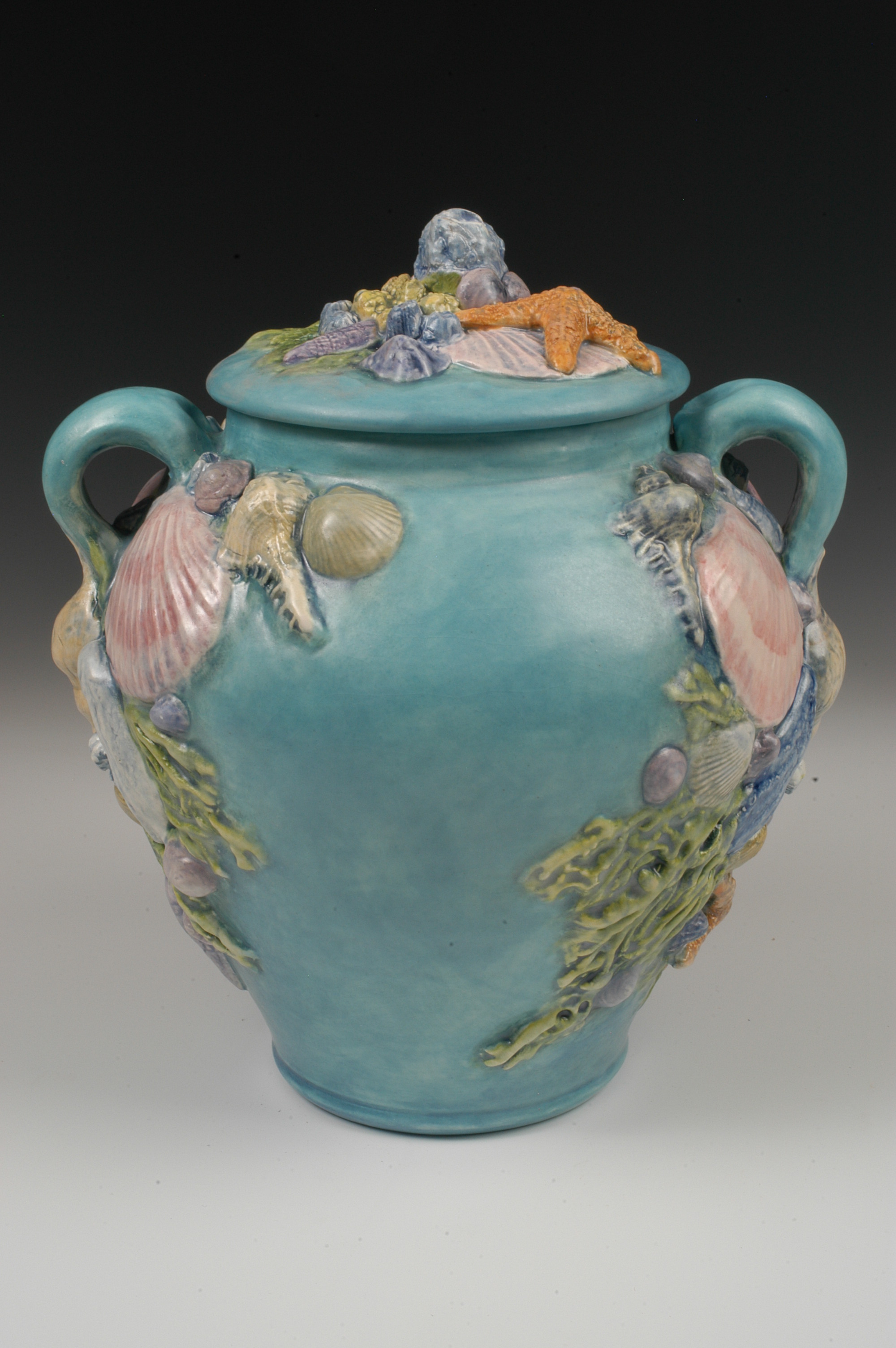 Teal ceramic memorial urn with sea shells